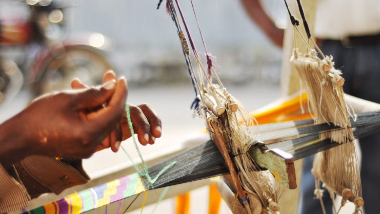Hands weaving kente cloth