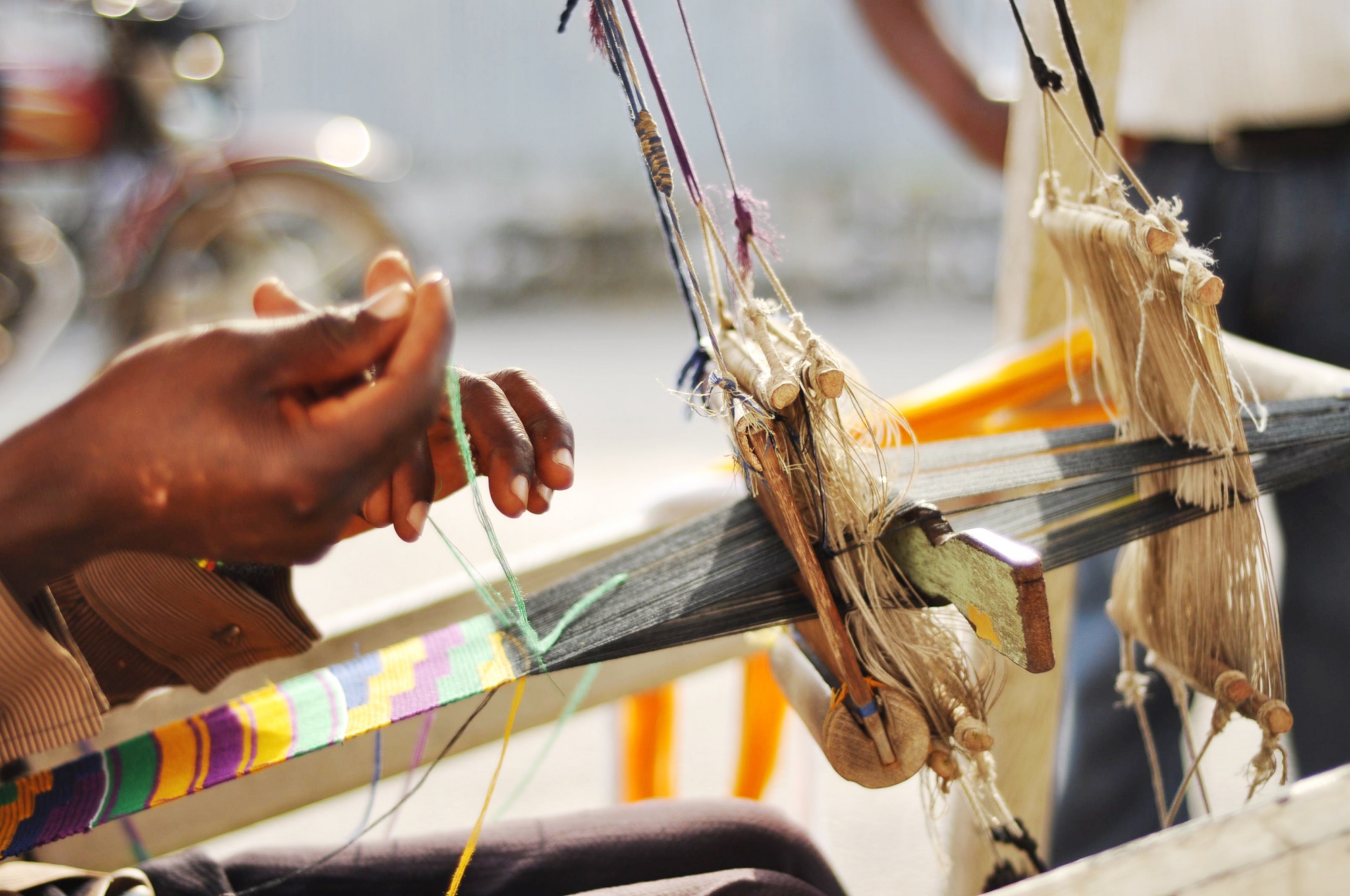 Hands weaving kente cloth